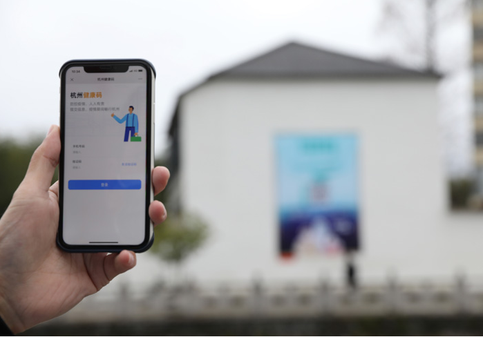 在浙江省杭州市臨安區(qū)天目山鎮(zhèn)，一名居民在“杭州健康碼”海報上掃碼申領(lǐng)個人二維碼。新華社發(fā)