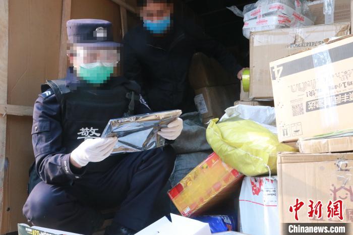 圖為勐康邊檢站民警在對(duì)快遞運(yùn)輸車(chē)輛進(jìn)行例行檢查。　楊添 攝
