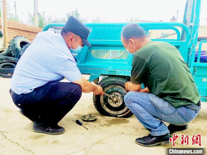 賽旦與民警共同維修三輪摩托車?！∫懒窘?攝