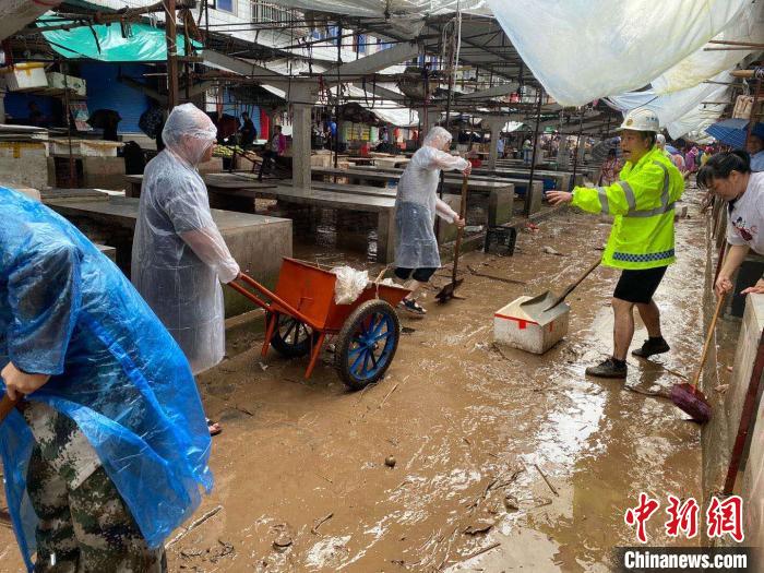 圖為7月26日，暴雨引發(fā)的洪水過境后，重慶萬州區(qū)分水鎮(zhèn)政府干部職工及志愿者清掃淤泥和垃圾?！　≈貞c萬州區(qū)委宣傳部供圖 攝