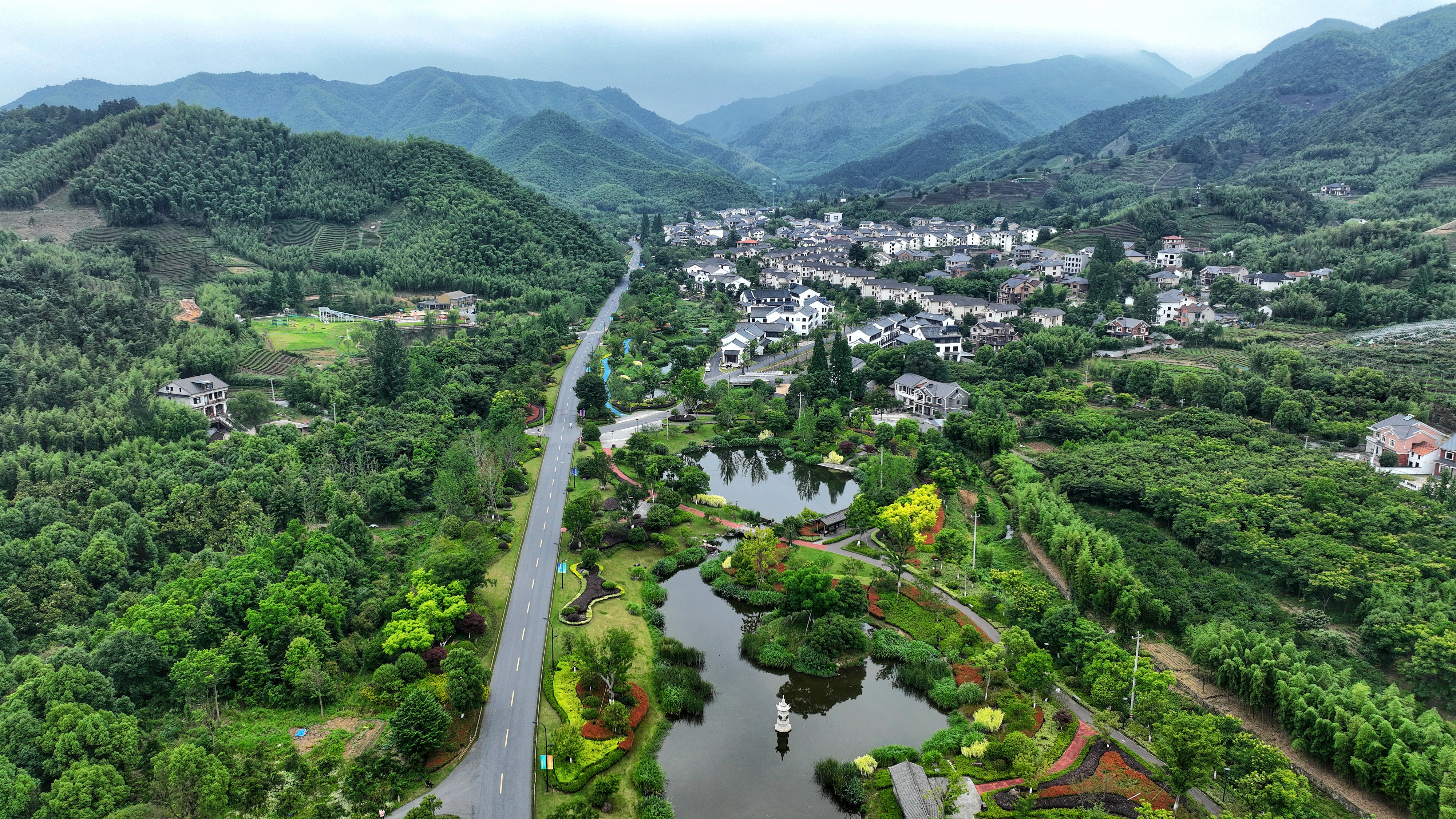2023年6月6日，杭州余杭區(qū)徑山鎮(zhèn)鄉(xiāng)村，生態(tài)碧水、沿路花海與村莊農(nóng)房相映成趣，構(gòu)成一幅美麗的山水田園畫。