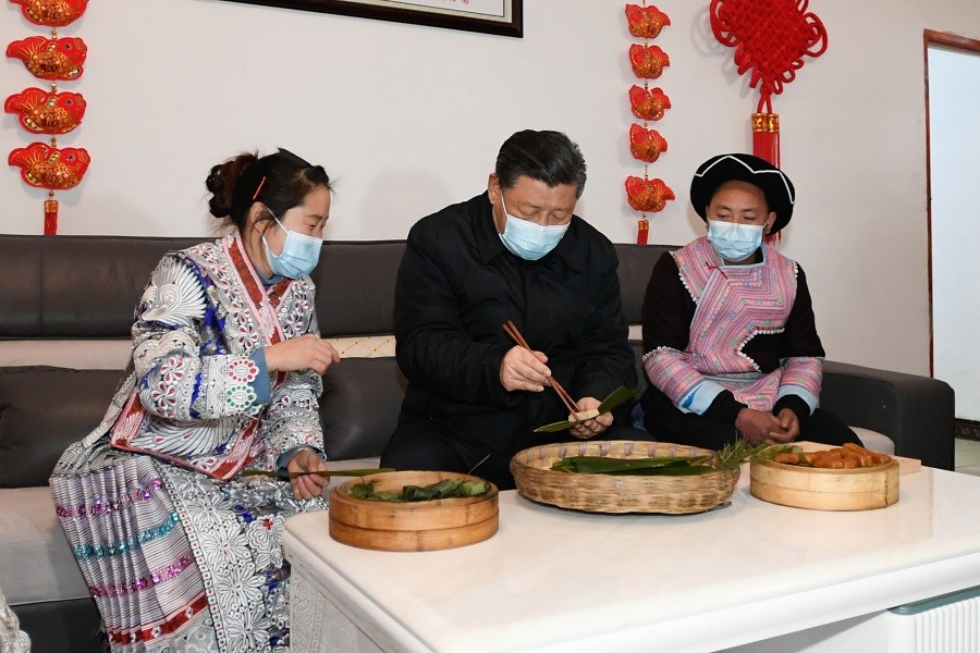 2021年2月3日下午，習近平在貴州畢節(jié)市黔西縣新仁苗族鄉(xiāng)化屋村苗族村民趙玉學家，同一家人邊聊家常邊制作當地傳統(tǒng)節(jié)日食品黃粑。新華社記者 李學仁 攝
